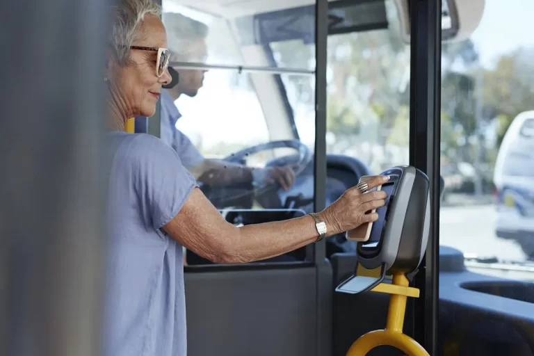 Mujer-madura-con-smartphone-para-pagar-el-viaje-en-autobus-publico-Mature-woman-using-smartphone-to-pay-for-public-bus-ride